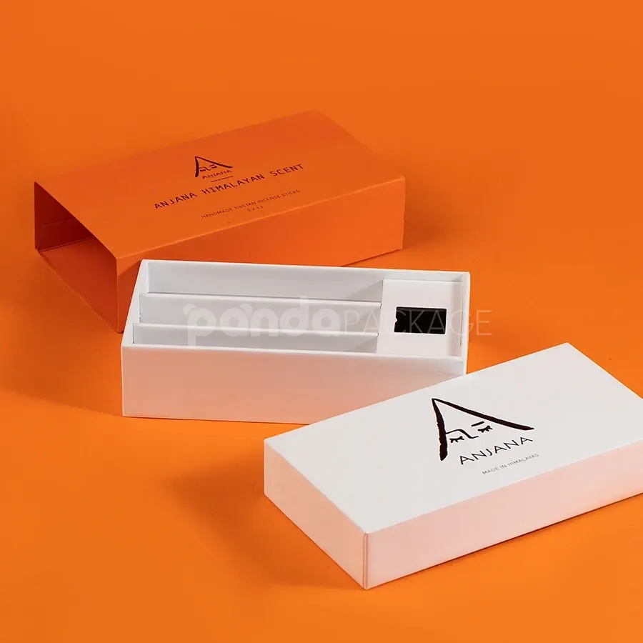 Ivory rigid lift-off box with orange sleeve packaging