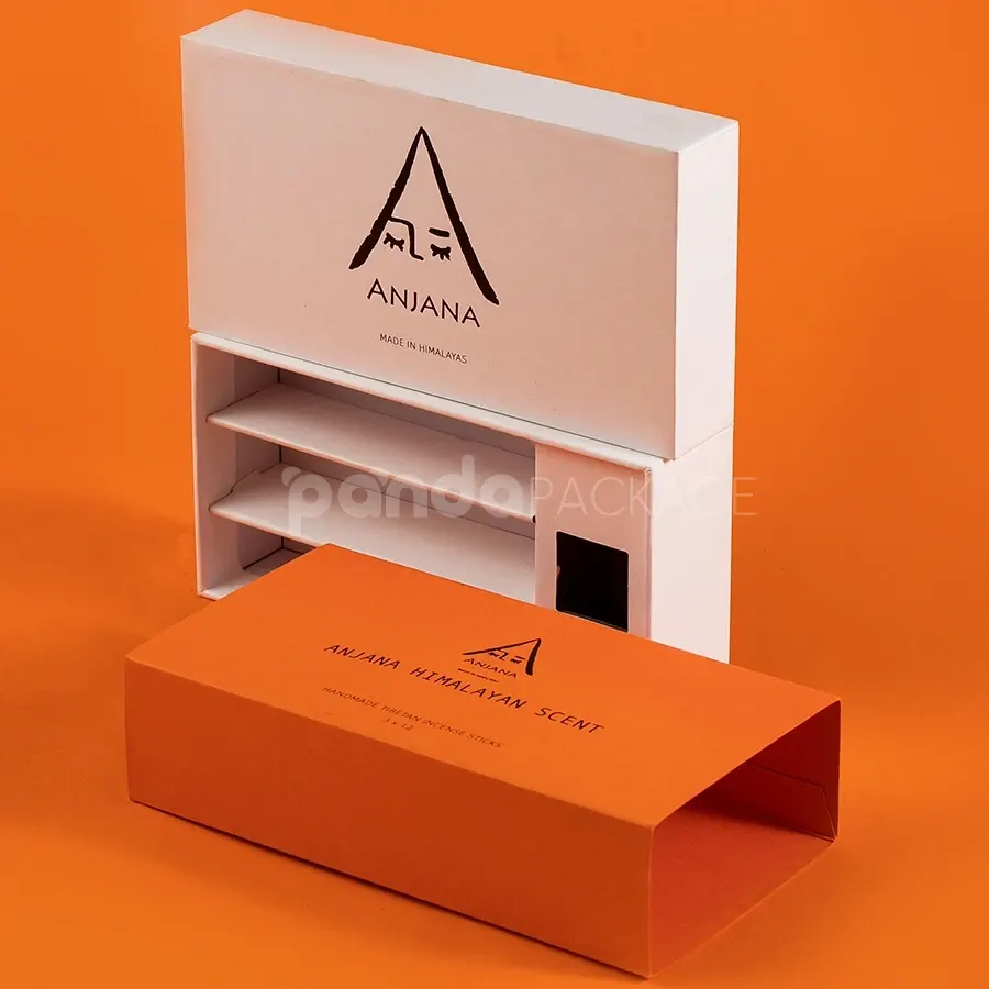 Ivory rigid lift-off box with orange sleeve packaging