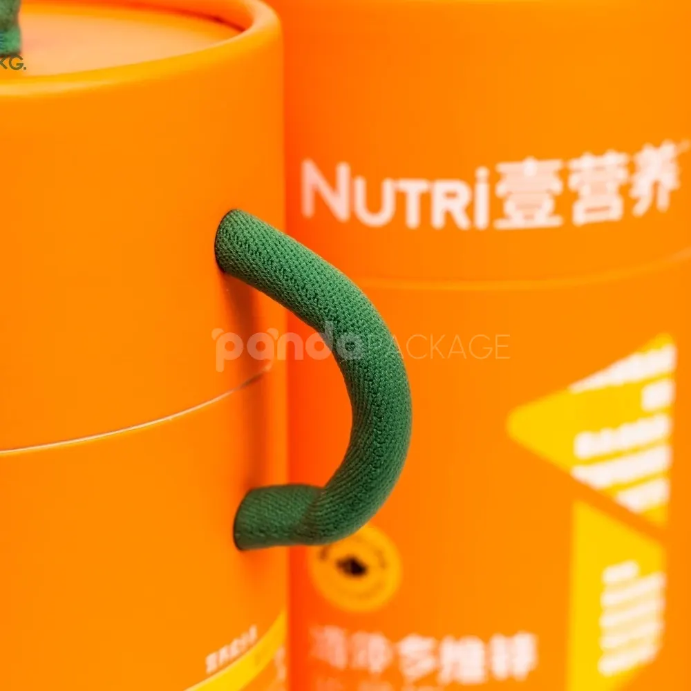 Bright orange paper cylinder with green rope handle for safe food packaging and portable presentation