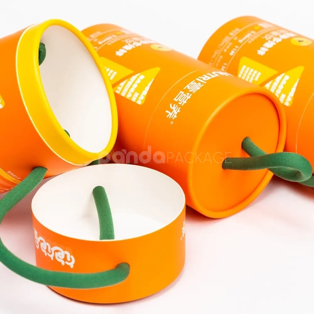 Bright orange paper cylinder with green rope handle for safe food packaging and portable presentation