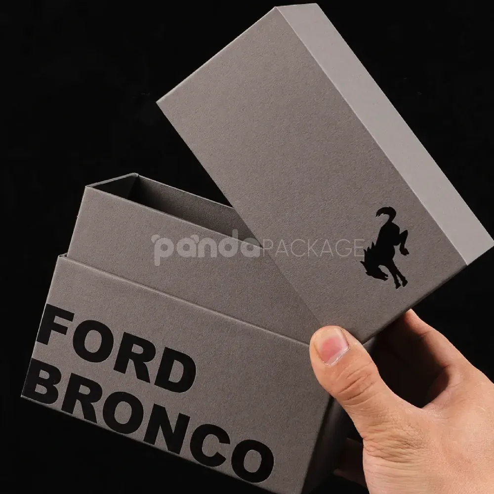 Luxury grey rigid box with lift-off lid and black foil stamped logo