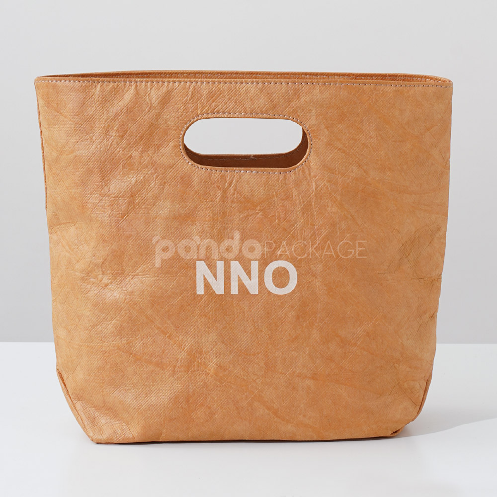 Reusable kraft-look non-woven tote bag with die-cut handles on display