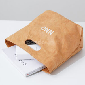 Reusable kraft-look non-woven tote bag with die-cut handles on display