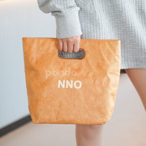 Reusable kraft-look non-woven tote bag with die-cut handles on display