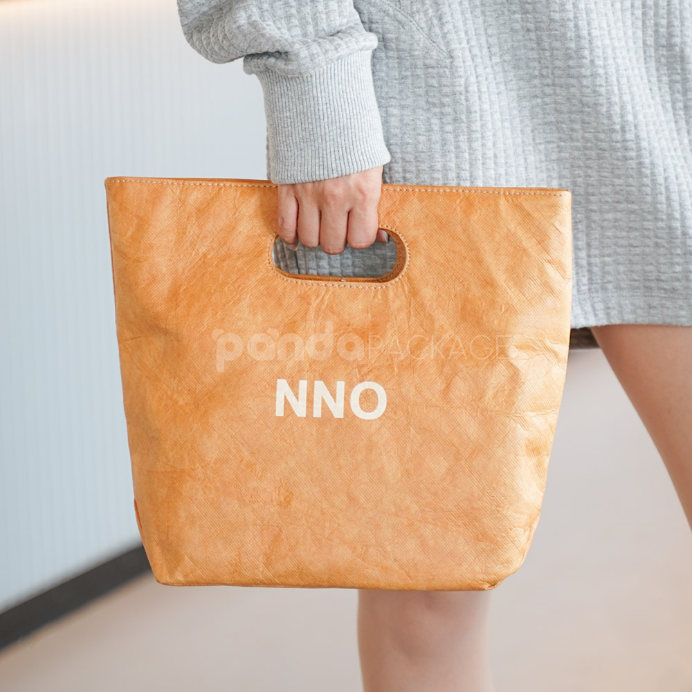 Reusable kraft-look non-woven tote bag with die-cut handles on display