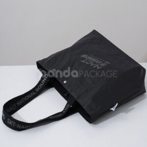 branded black paper bag with long webbing handles