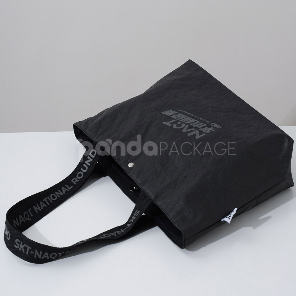 branded black paper bag with long webbing handles