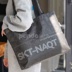 branded black paper bag with long webbing handles