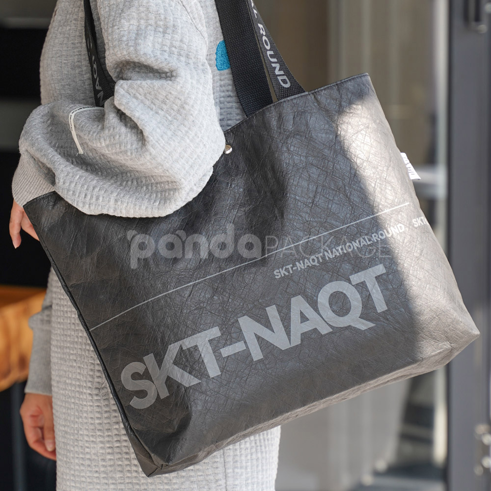 branded black paper bag with long webbing handles