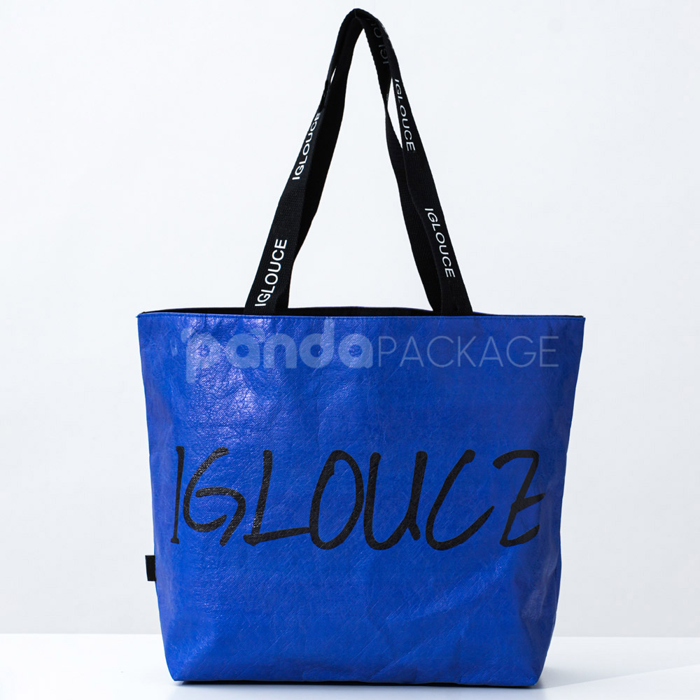 Blue paper tote bag with black branded handles