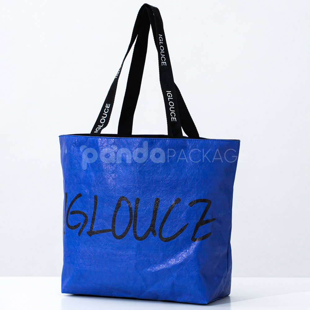 Blue paper tote bag with black branded handles