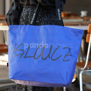 Blue paper tote bag with black branded handles
