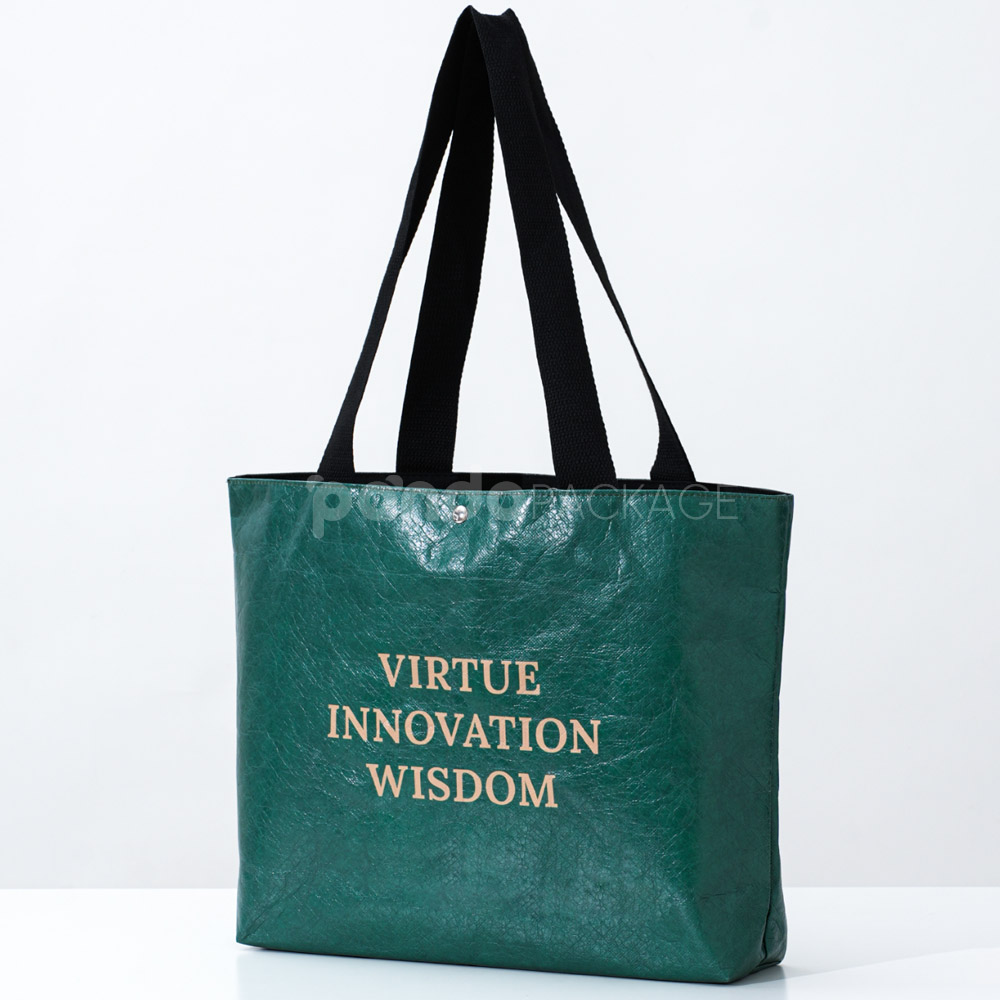 green paper tote bag with inspirational text and black handles