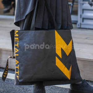Black paper tote bag with metallic gold lightning graphic