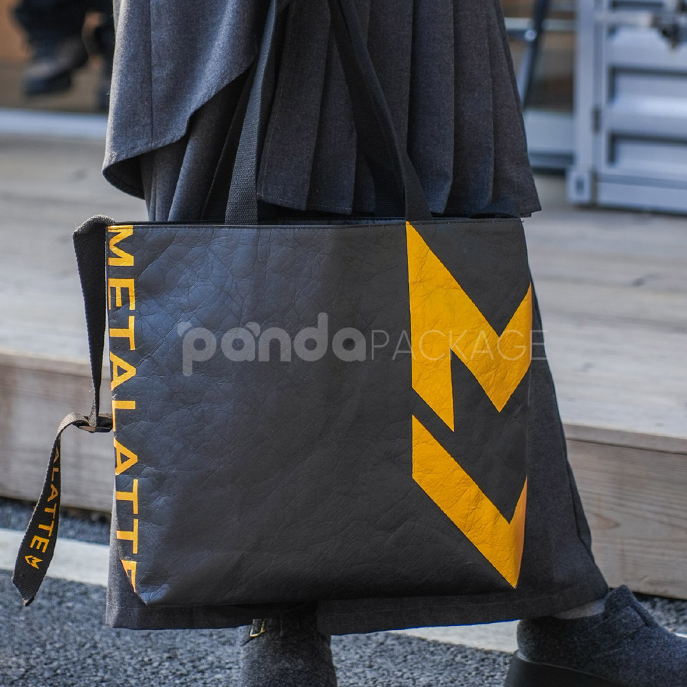 Black paper tote bag with metallic gold lightning graphic