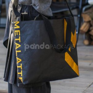 Black paper tote bag with metallic gold lightning graphic