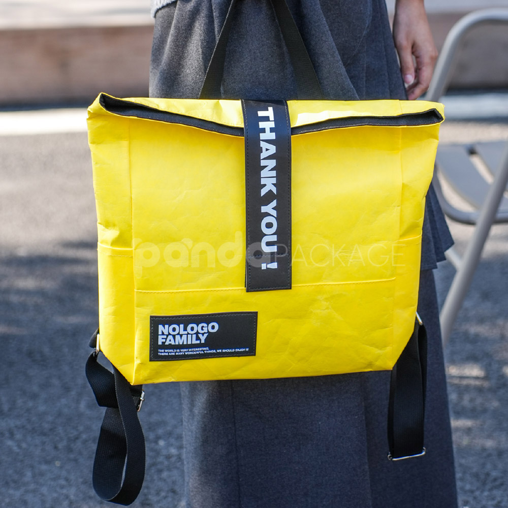 yellow tyvek backpack with black strap and patch logo