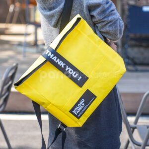 yellow tyvek backpack with black strap and patch logo