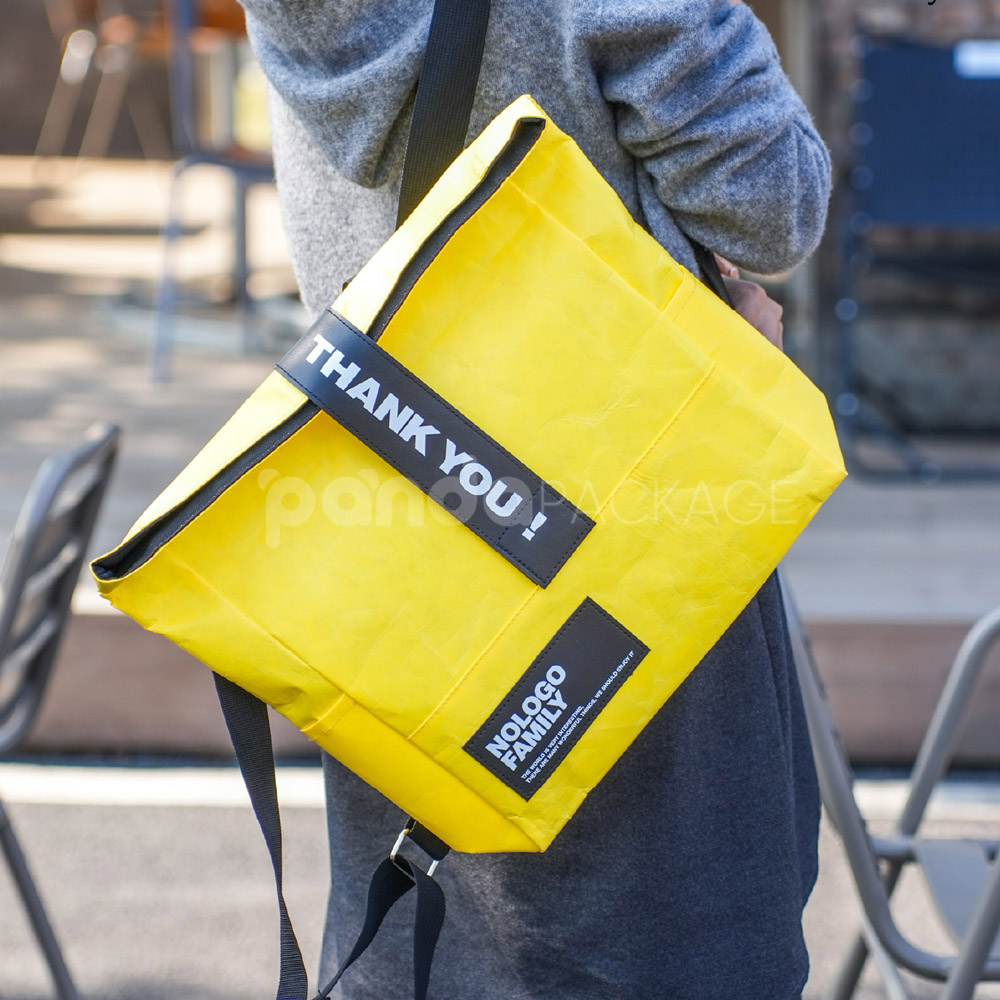 yellow tyvek backpack with black strap and patch logo