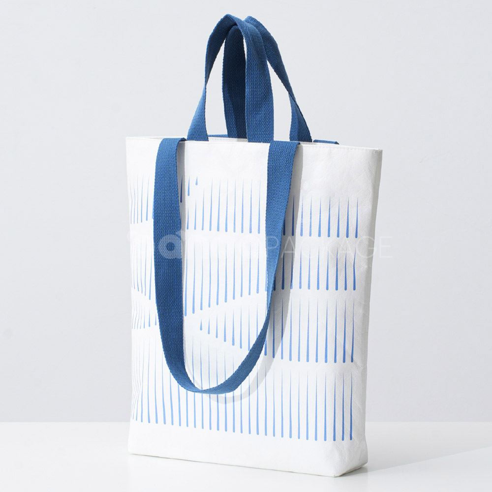 Ivory tote bag with blue woven handles and abstract line pattern