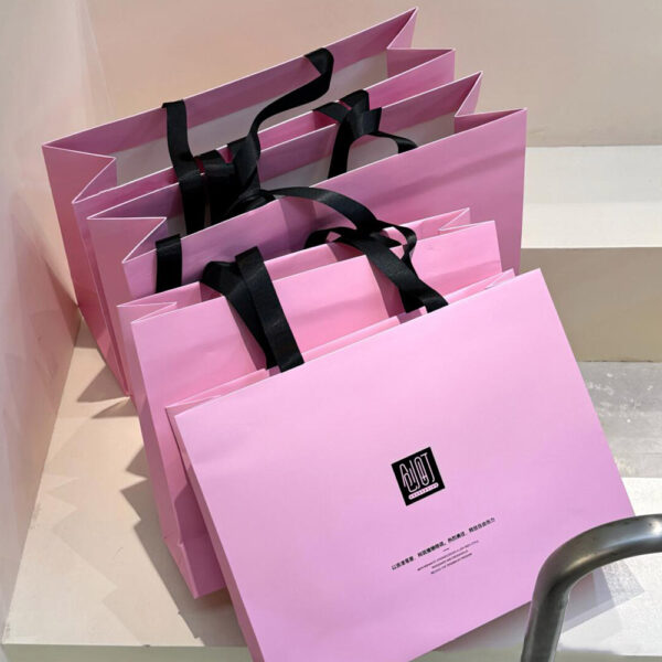 Pink Apparel Shopping Bag with Black Handles and Logo