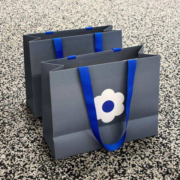 Gray Apparel Shopping Bag with Blue Handles and Flower Print