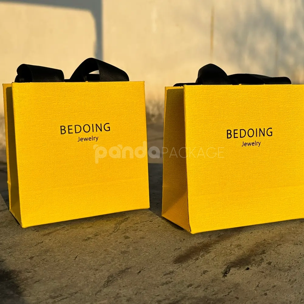 Luxury yellow textured paper bag with black ribbon handles