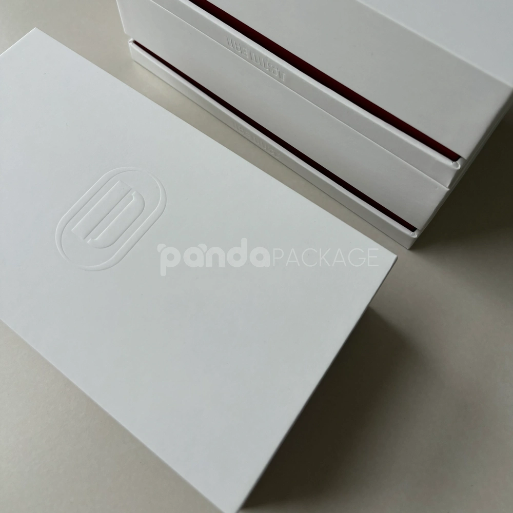 White lift-off rigid gift box with embossed logo and red accent