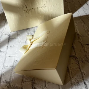 luxury cream paper gift bag with embossed text and ribbon bow