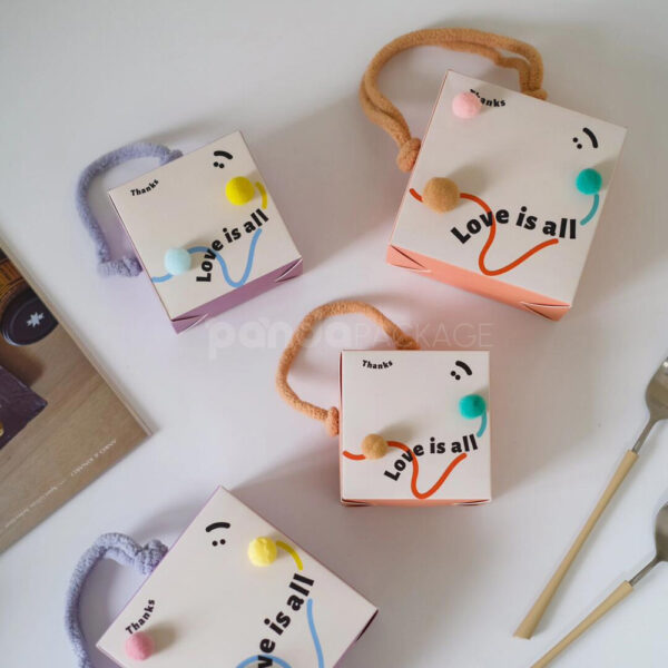 Playful Candy Gift Box with Colorful Pom-Poms and Pink Handle
