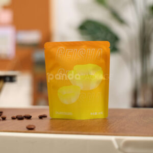 small gradient yellow–orange stand-up coffee pouch with matte surface