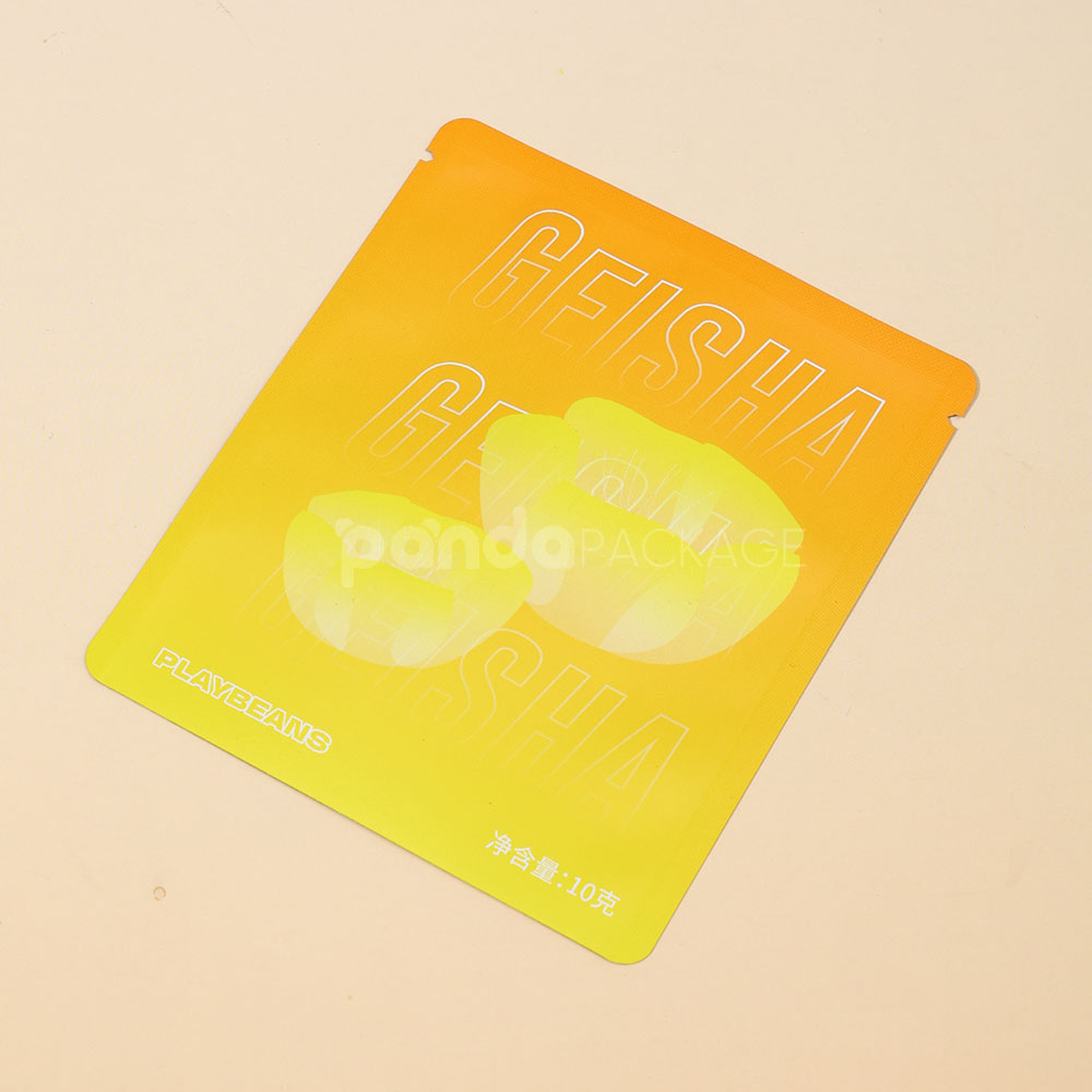 small gradient yellow–orange stand-up coffee pouch with matte surface