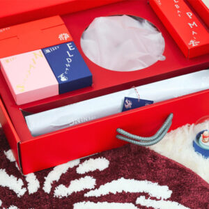 red rigid gift box with rope handle and silver foil stamping for festive holiday packaging