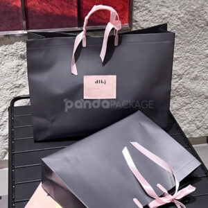 laminated non-woven tote bags with plastic handles and ribbon bow for apparel packaging in customizable colors and sizes