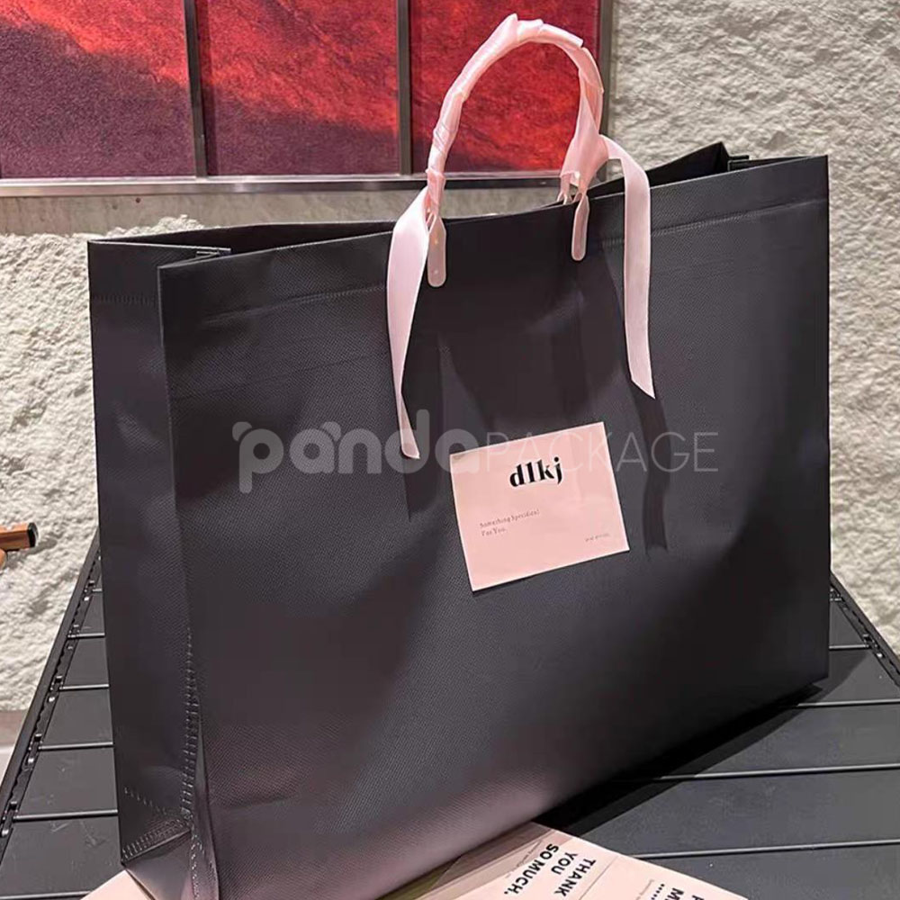 laminated non-woven tote bags with plastic handles and ribbon bow for apparel packaging in customizable colors and sizes