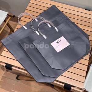 laminated non-woven tote bags with plastic handles and ribbon bow for apparel packaging in customizable colors and sizes