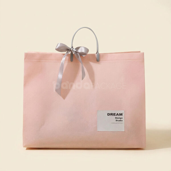Laminated Non-Woven Tote Bags with Plastic Handles and Ribbon Bow for Apparel Packaging