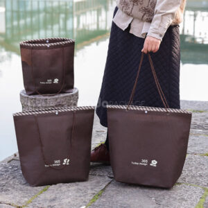tapered non-woven tote bags with rope handles and piping edges, available in multiple colors and custom sizes for apparel packaging