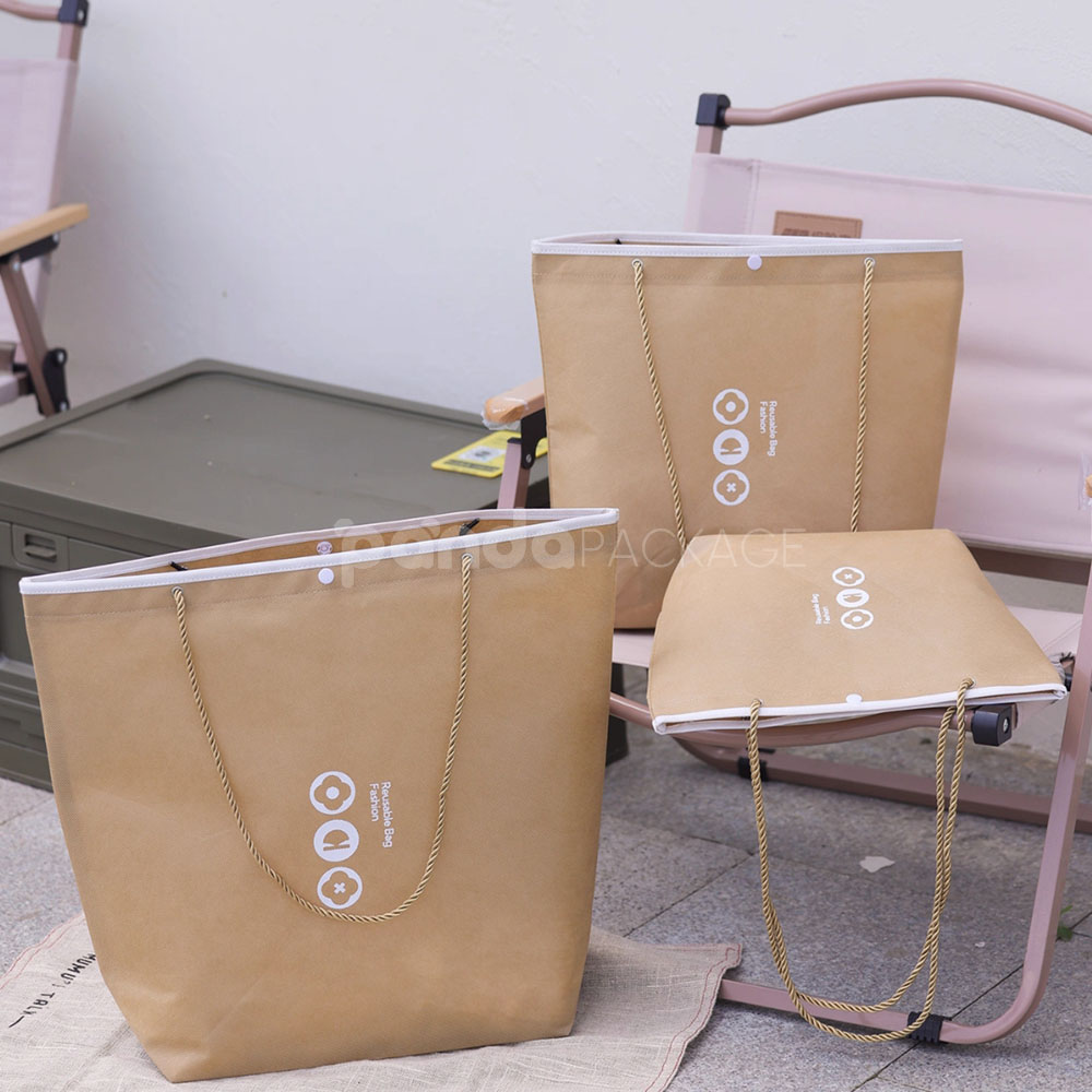 tapered non-woven tote bags with rope handles and piping edges, available in multiple colors and custom sizes for apparel packaging