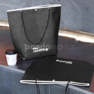 tapered non-woven tote bags with rope handles and piping edges, available in multiple colors and custom sizes for apparel packaging