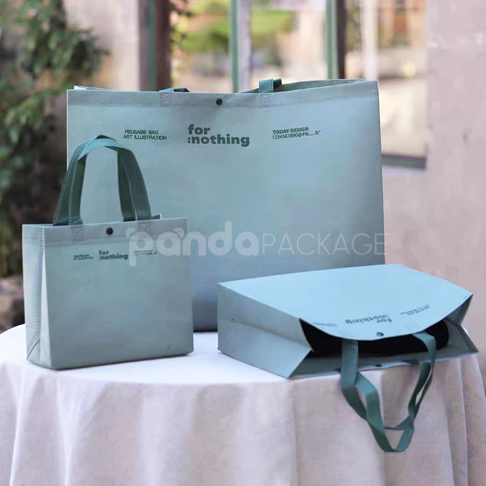 thickened non-woven tote bags with reinforced handles and snap button closure, custom printed for apparel and retail packaging