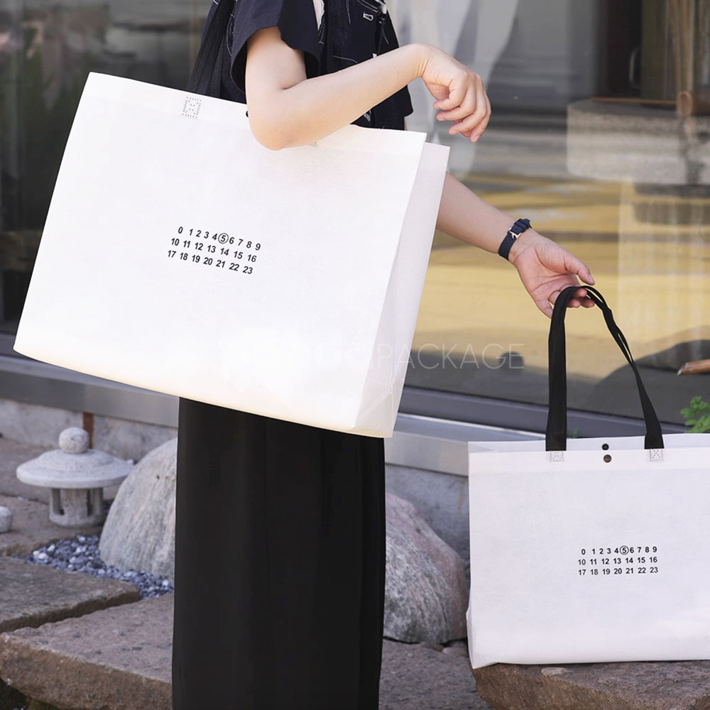 thickened non-woven tote bags with reinforced handles and snap button closure, custom printed for apparel and retail packaging
