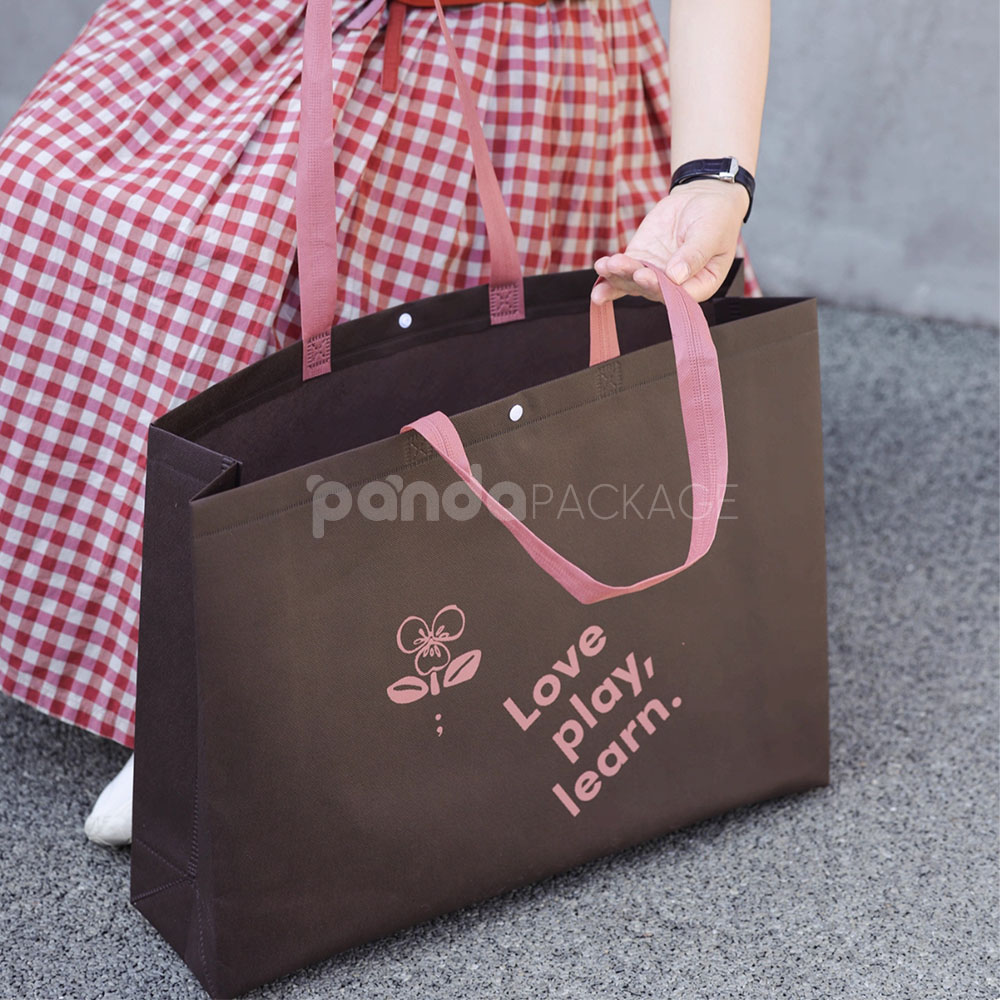 thickened non-woven tote bags with reinforced handles and snap button closure, custom printed for apparel and retail packaging