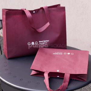 thickened non-woven tote bags with reinforced handles and snap button closure, custom printed for apparel and retail packaging