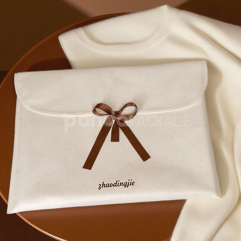 cream non-woven clothing packaging bag with ribbon bow closure