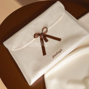 cream non-woven clothing packaging bag with ribbon bow closure