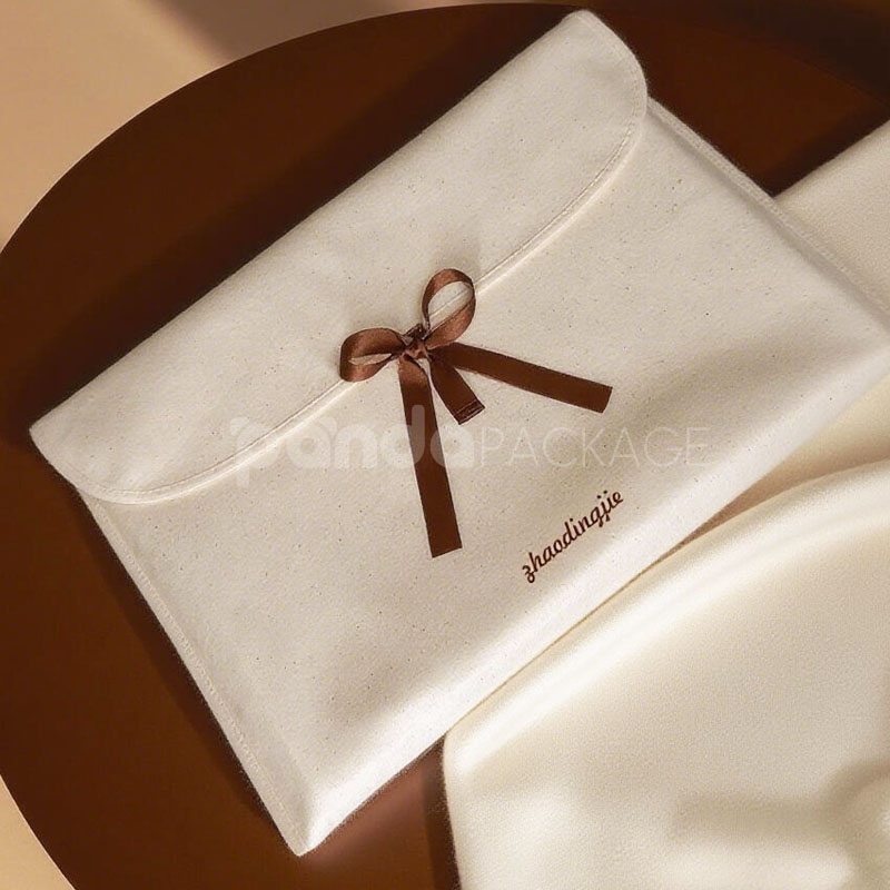 cream non-woven clothing packaging bag with ribbon bow closure