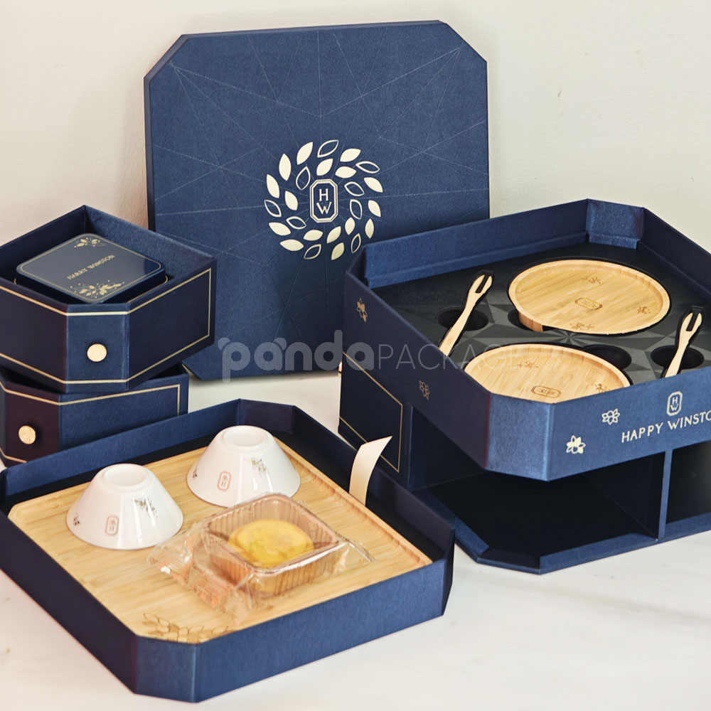 luxury octagonal rigid gift box in royal navy blue with gold foil logo, matching paper bag, and multi-drawer design for premium gifting
