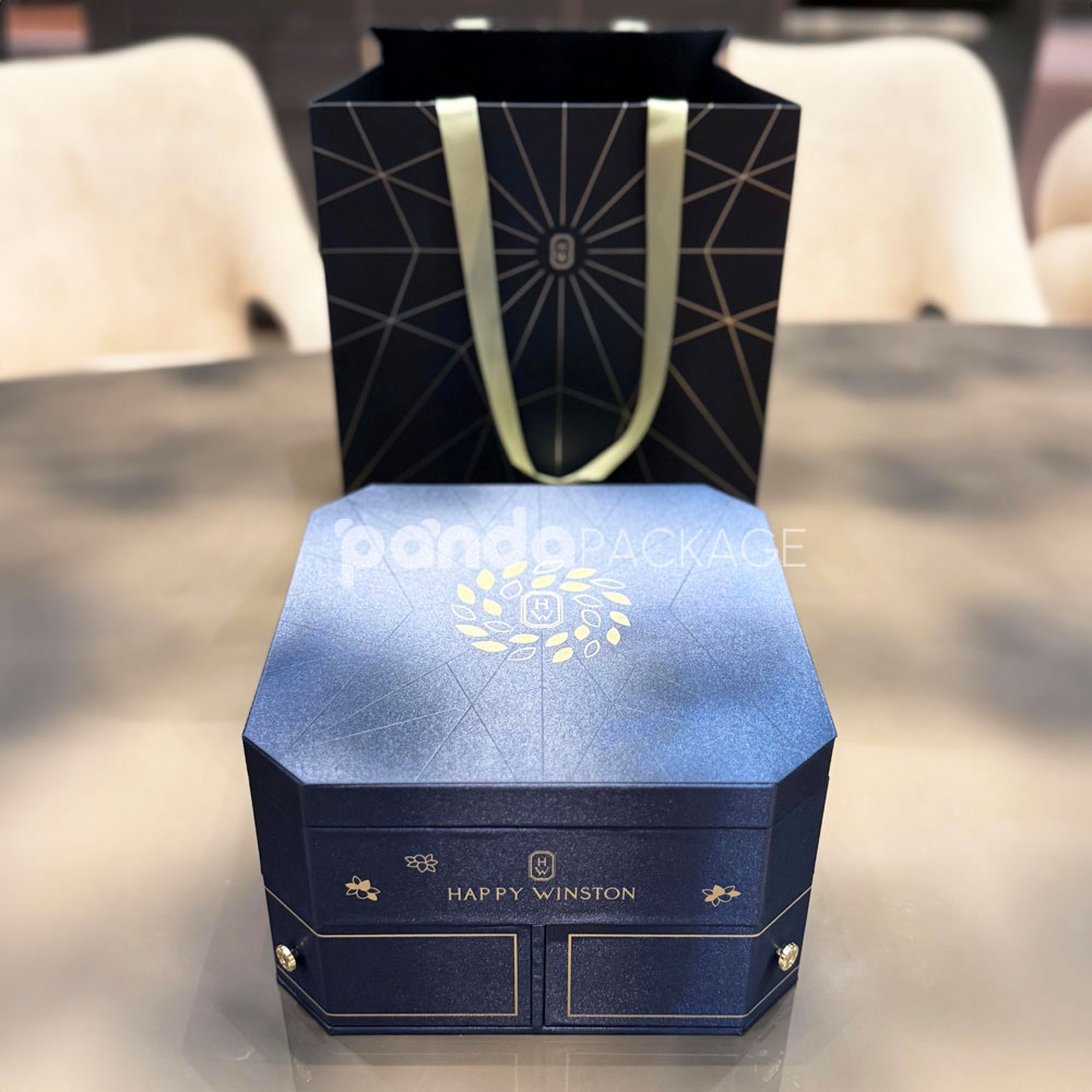 luxury octagonal rigid gift box in royal navy blue with gold foil logo, matching paper bag, and multi-drawer design for premium gifting