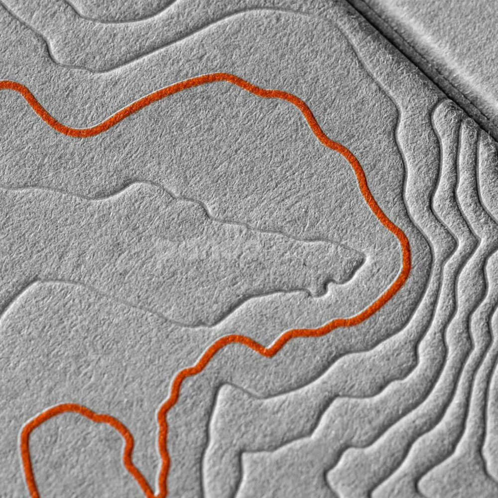 luxury textured grey paperboard box for skincare packaging with embossed terrain pattern and orange foil line details
